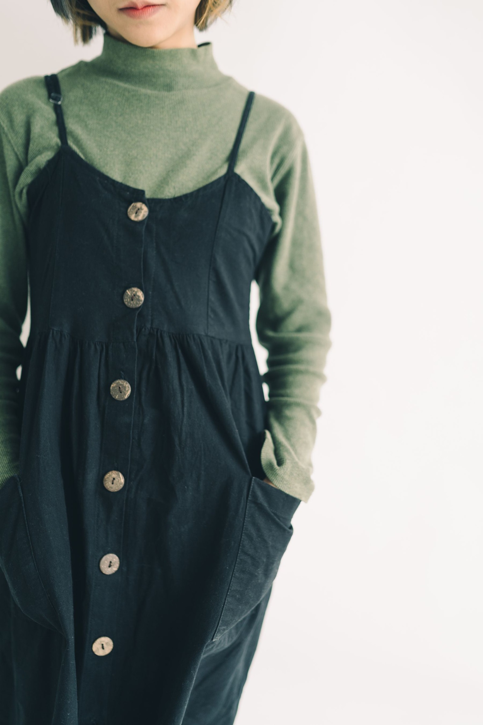 Close-up of a green turtleneck worn under a buttoned black dress