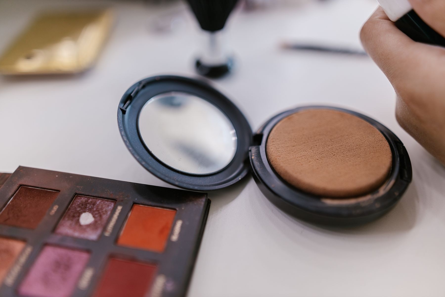 Makeup palette and compact powder on a table