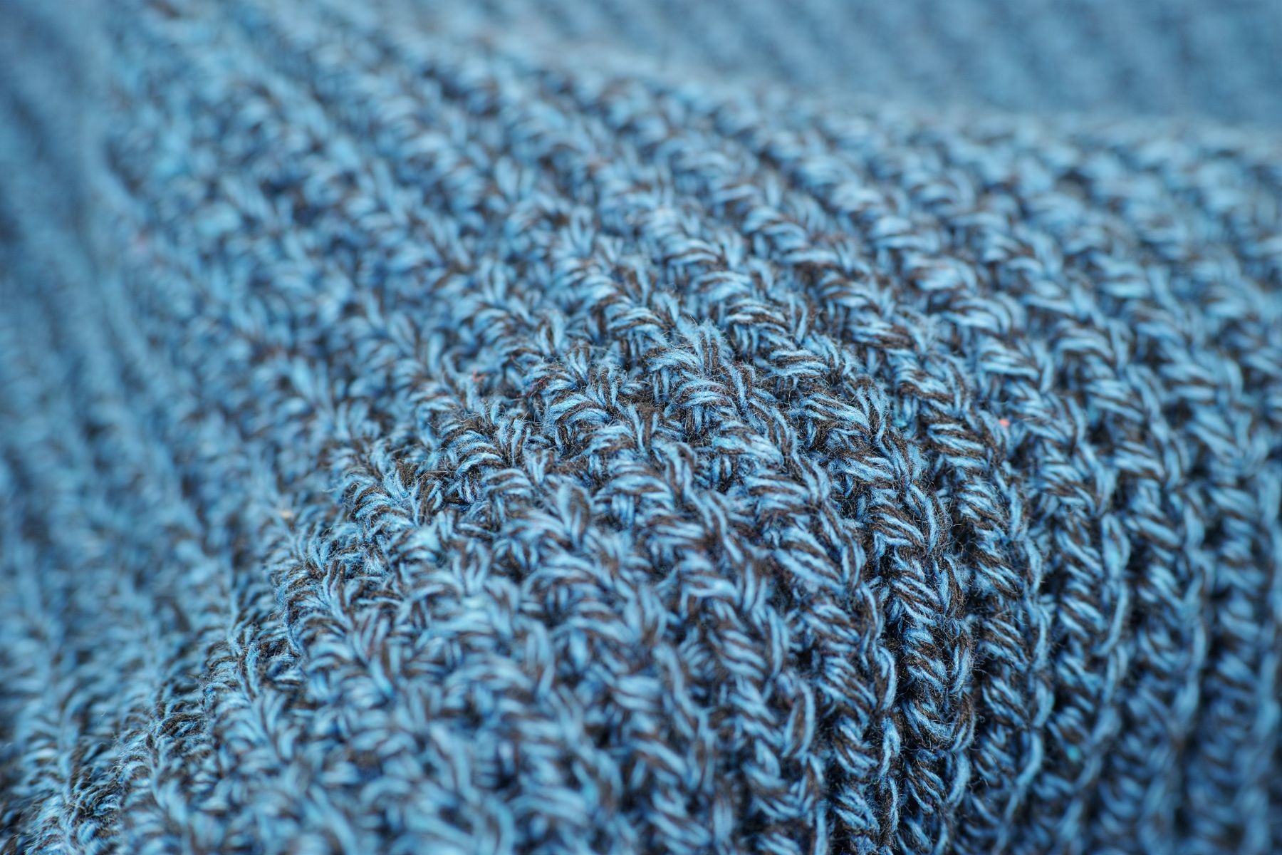 Close-up of blue-gray knitted wool fabric showing its loops and texture