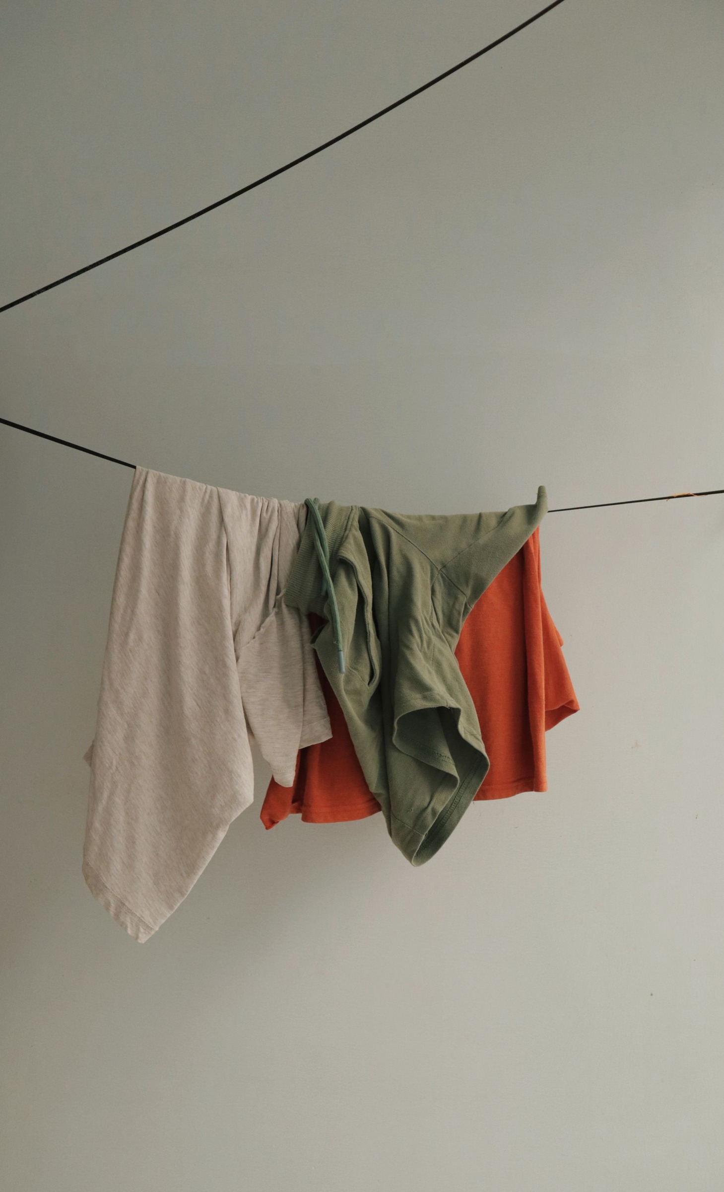 Colorful clothes hanging to dry on a line against a wall
