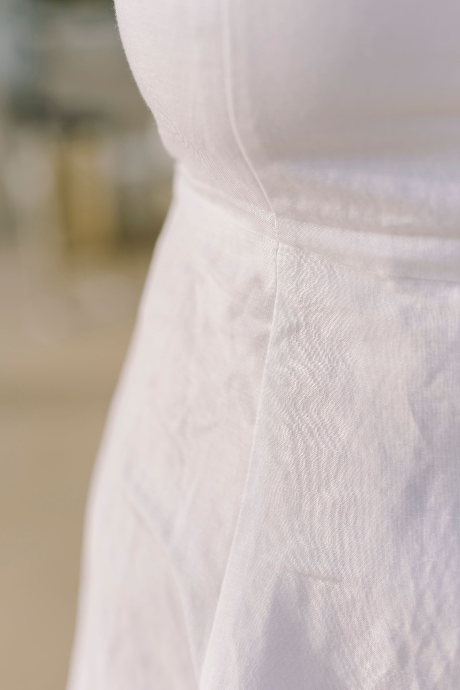 Close-up of a white sundress showing seams and gathered fabric