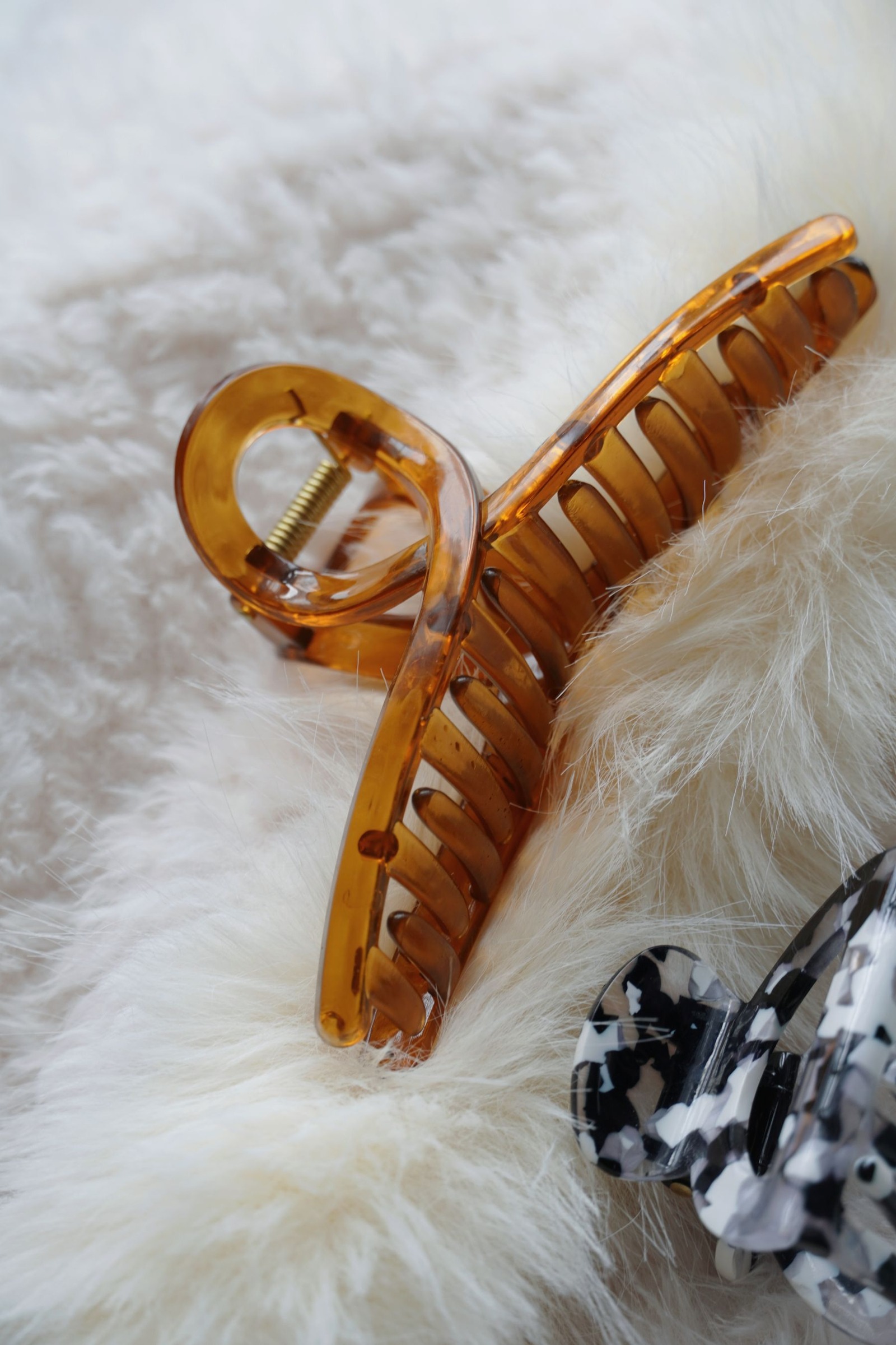 Close-up of a tortoiseshell hair claw clip on textured fabric
