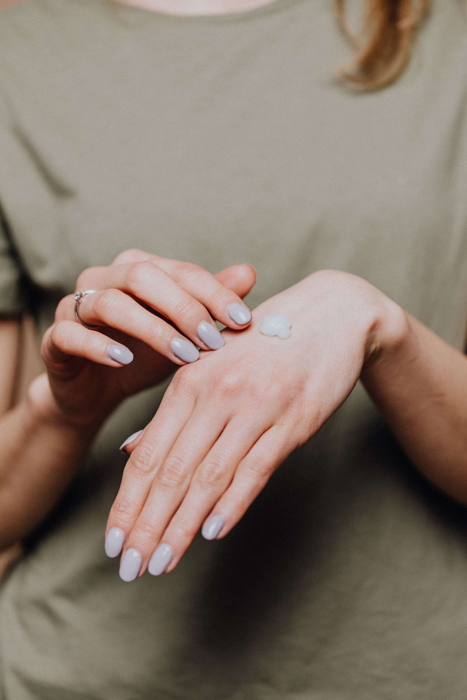 Hand with a ring and a small dab of moisturizer on its back