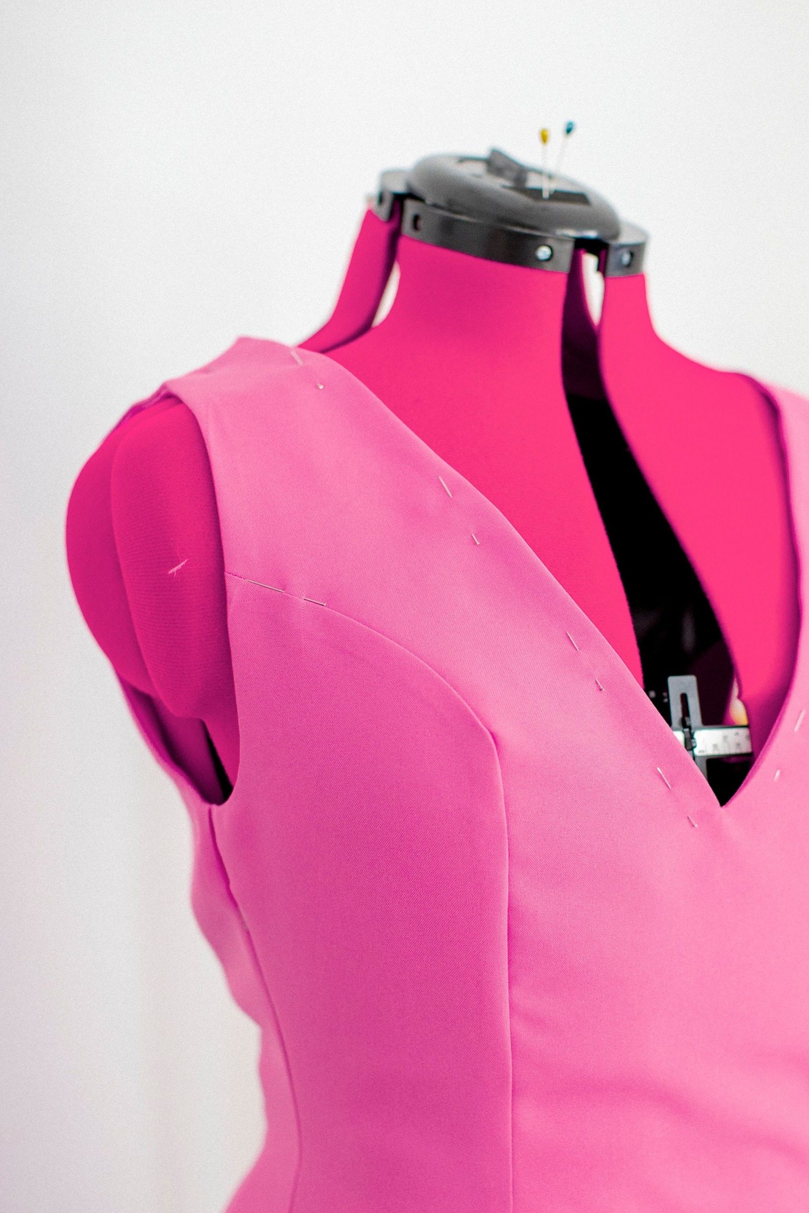 Pink sleeveless dress on a dress form in close-up