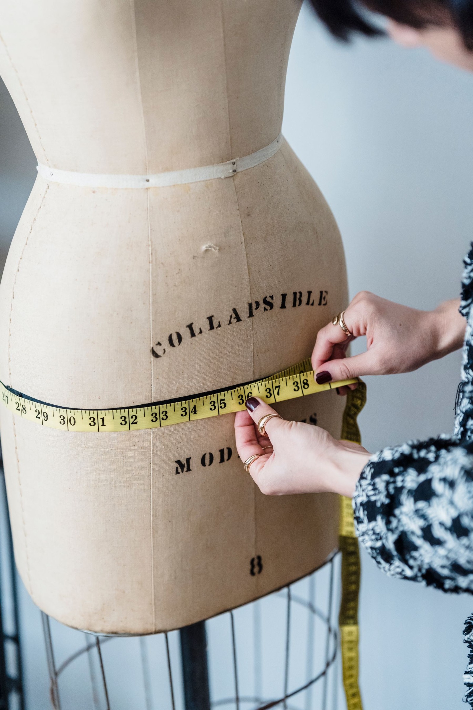 Dressmaker measuring the hip line of a dress form