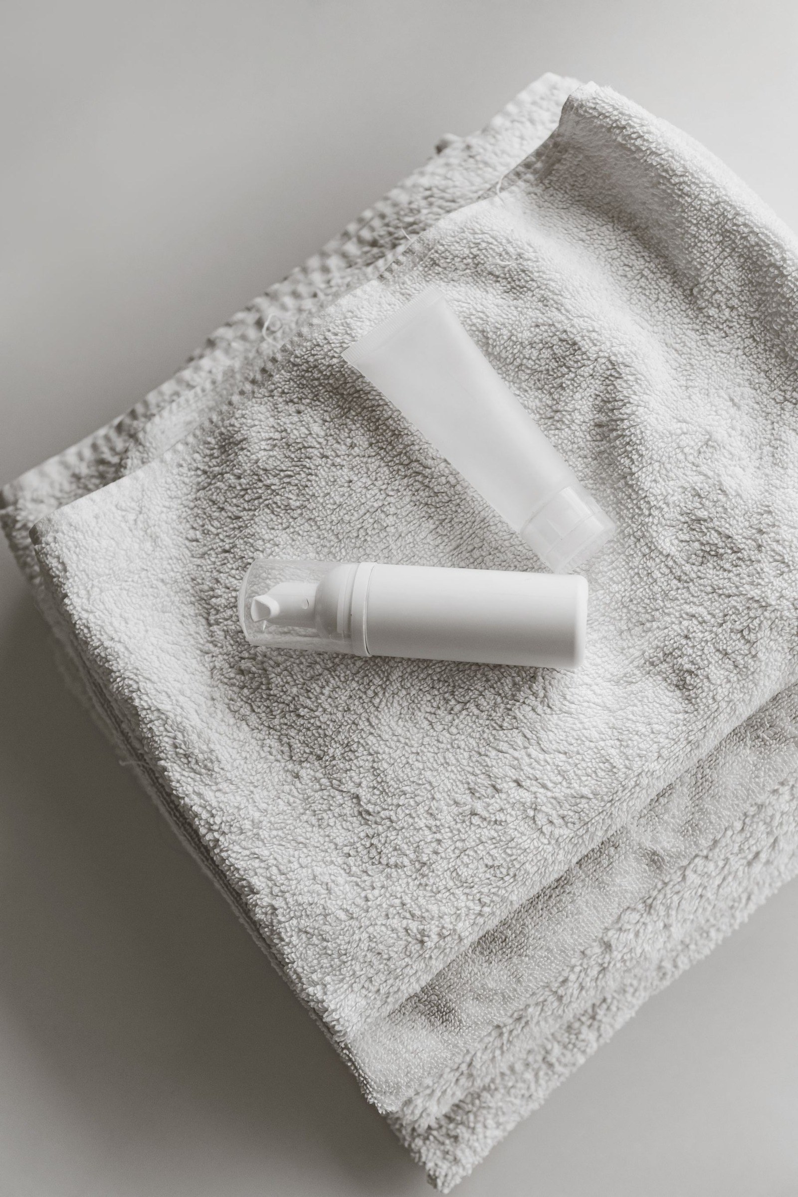 Skincare bottles arranged on a white towel