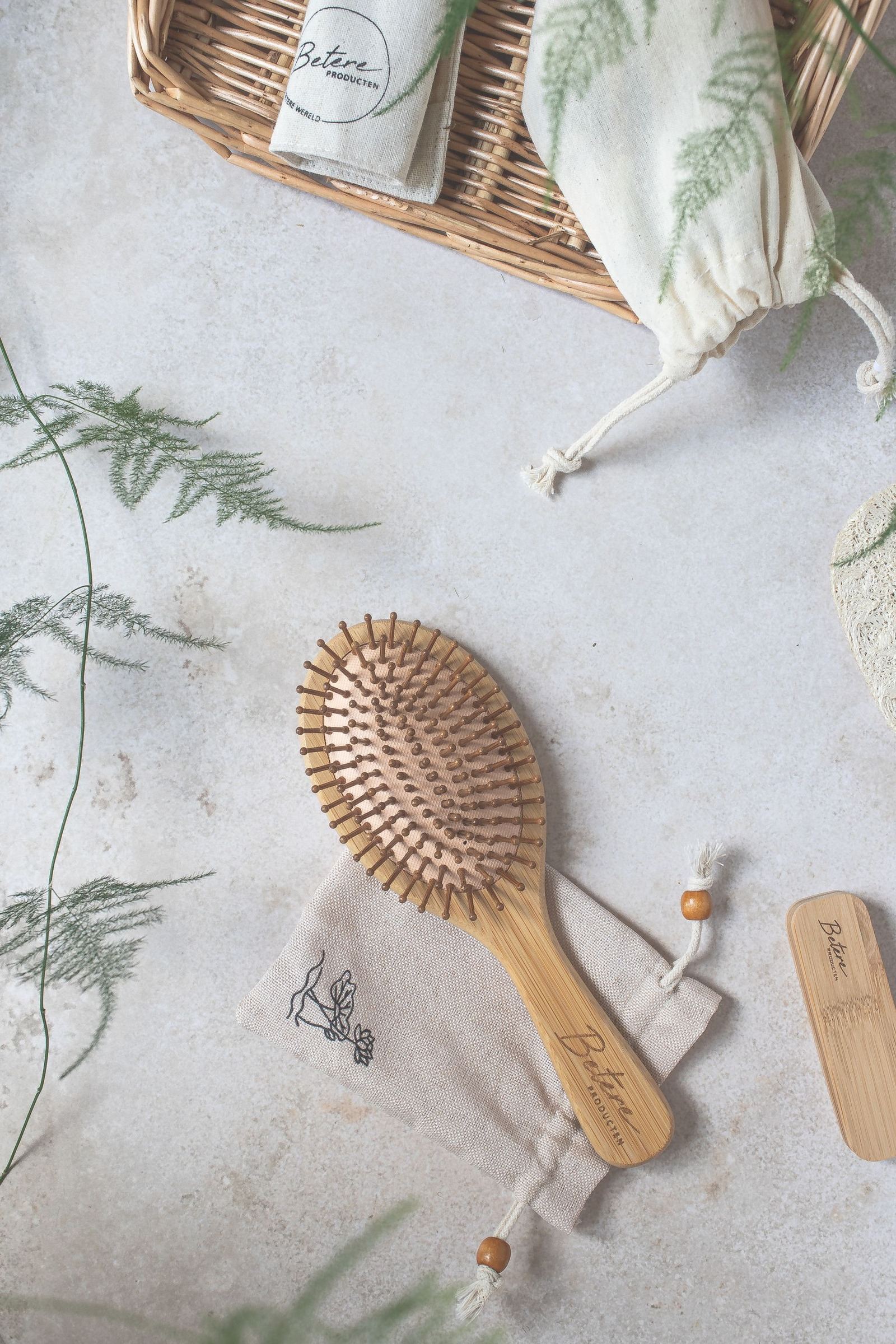 Wooden hairbrush beside a woven basket and cloth pouch