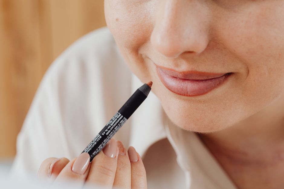 Close-up image of a woman applying lip liner with precision, highlighting beauty and self-